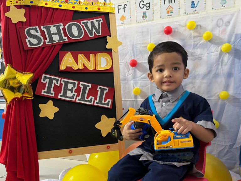A child presenting a toy vehicle during Show & Tell at Excel Kids
